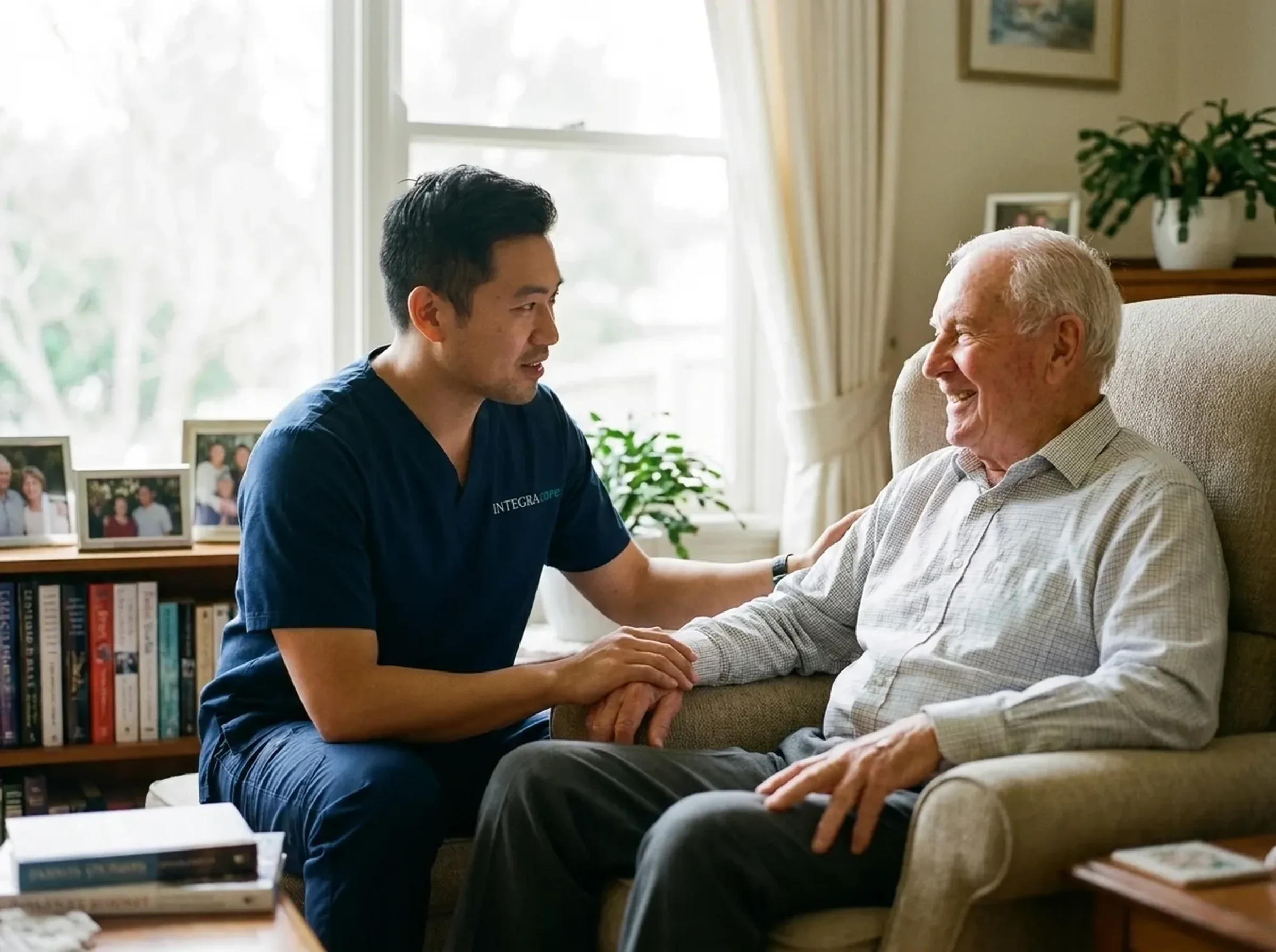 A caregiver sitting knee to knee, listening warmly to an elderly man at home
